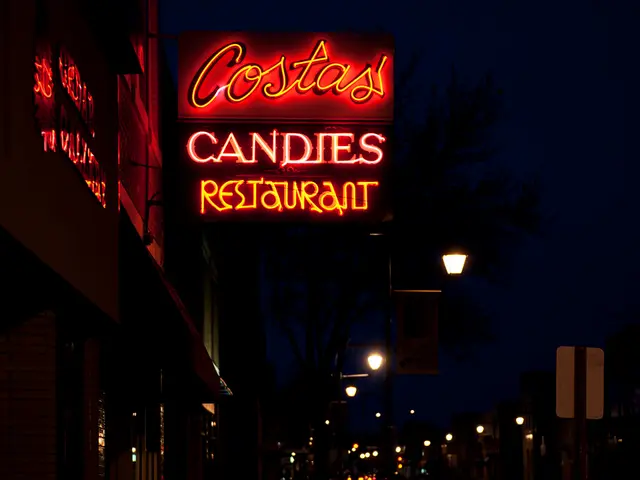 The picture is taken at the night time on a street. On the left side there are buildings. In the...
