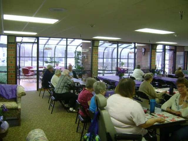 The image is clicked inside the room. There are many people sitting in their chairs near the...