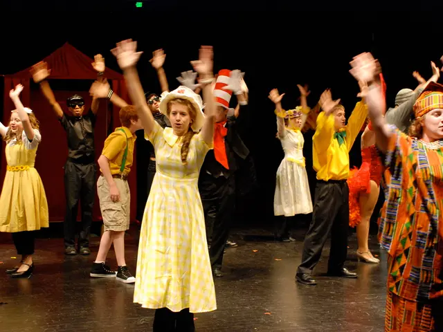 The picture is taken over a stage, on the stage there are lot of people dancing. They are wearing...