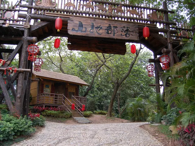 In the image there is a wooden house and around the house there is a lot of greenery. In front of...