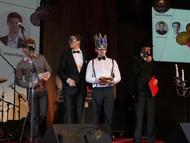 In this image we can see a four people who are standing on a stage. The person on the right side is...