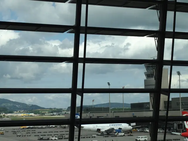 This image is clicked from a window, behind it there is an aeroplane on the road with vehicles in...