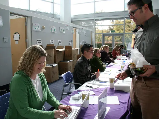 This picture is clicked inside the building. We can see many people sitting and working over here....