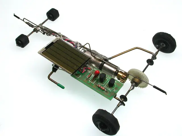 In this picture we can see the remote car. In the front there is a green circuit board with...