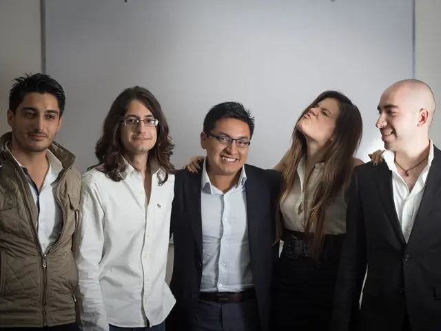 In this image there are group of people standing together and smiling behind them there is a board...