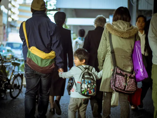 Here we can see a group of people walking through the road and there is a boy in between a couple...