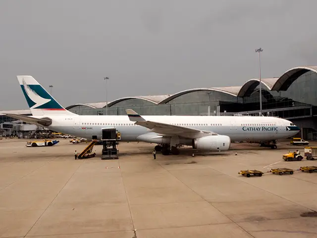 In this image I can see in the middle there is an aeroplane in white color. It looks like an...