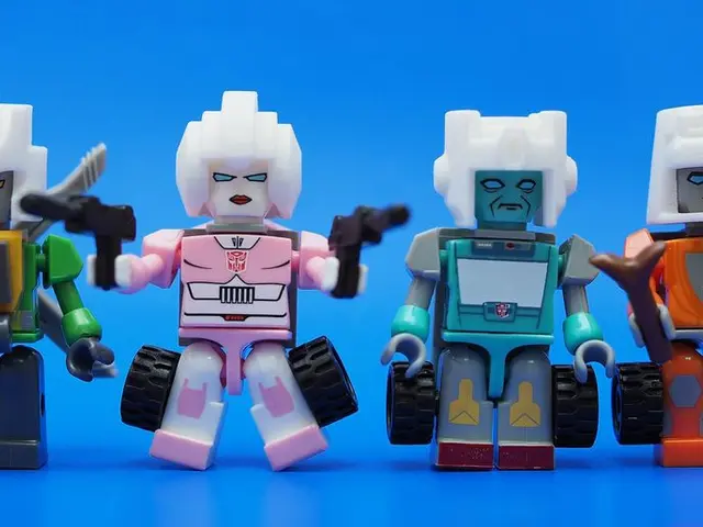 In this picture we can see 4 robot toys kept on a blue surface.