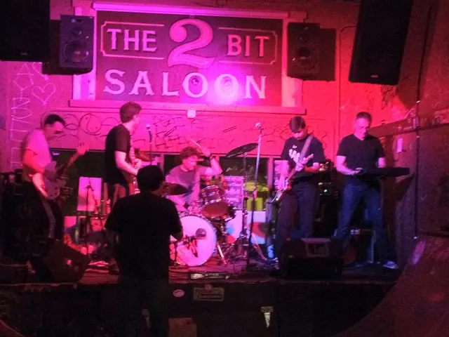 In the image we can see there are many people standing, they are wearing clothes and shoes. These...