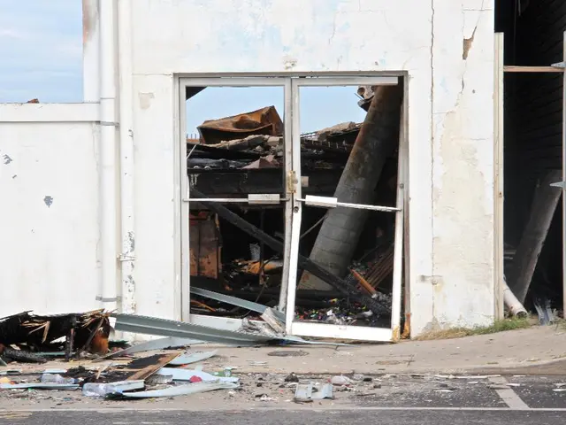 In this picture we can see a collapsed building and to the wall there are pipes. Behind the wall...