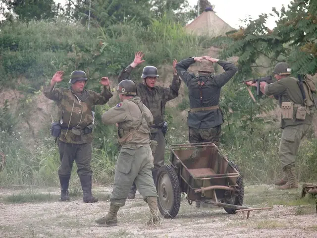 As we can see in the image there are few people wearing helmets and army dress. There is a cart,...