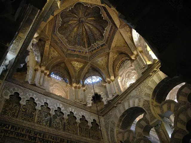 This image consists of a building, in which we can see the art on the walls. At the top, there is a...