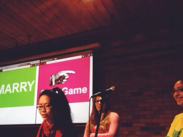 Here I can see three women are standing facing towards the left side. In the middle there is a mike...