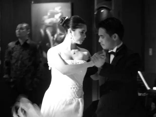 This picture shows a man and a woman dancing on the floor and women wore white color dress and we...