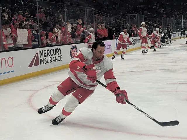 The image shows a group of people playing a game of hockey on an ice rink. They are all wearing...