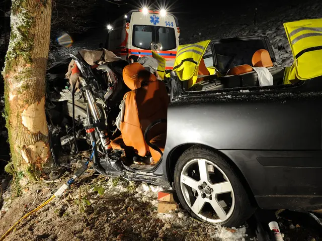 The image shows a car that has been involved in a crash on the side of the road, with an ambulance...