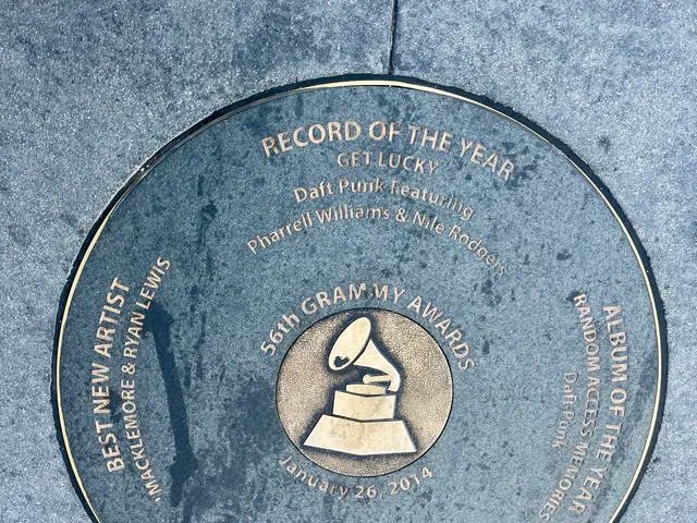 The image shows a record of the year award on the Hollywood Walk of Fame. It is a circular plaque...