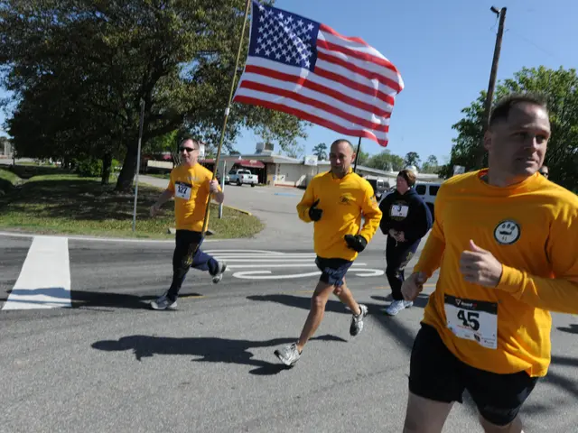The image shows a group of people running in a marathon, with an American flag in the background....
