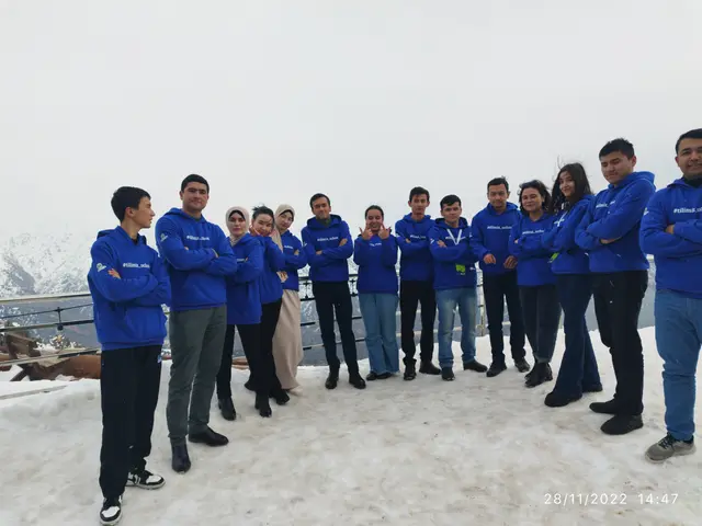 The image shows a group of people standing on top of a snow covered mountain, with a railing in the...