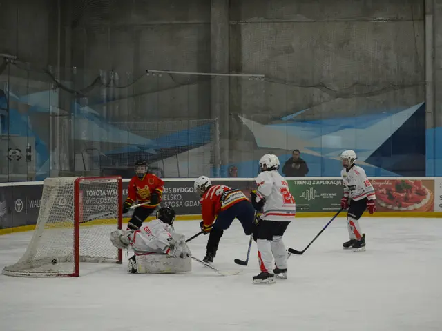 The image shows a group of people playing a game of ice hockey on an ice rink. They are all wearing...