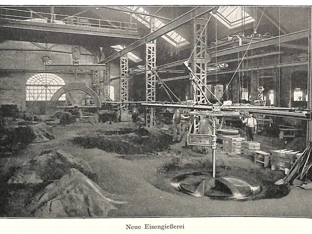 The image shows an old black and white photo of a factory with people working on a machine,...