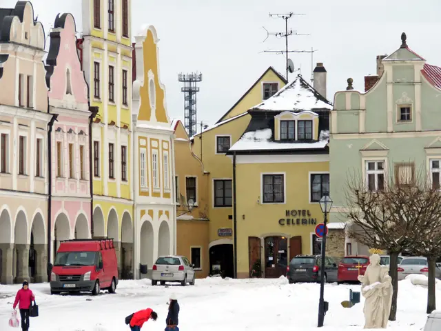 The image shows a group of people walking down a snow covered street in the old town of Cesky...