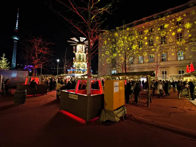 The image shows a bustling Christmas market in Berlin, Germany. There are many people gathered...