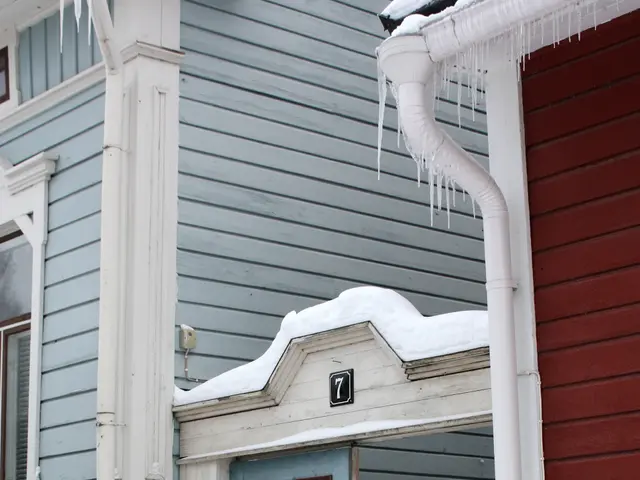 The image shows a house with a door covered in snow and icicles hanging from the roof. The door is...