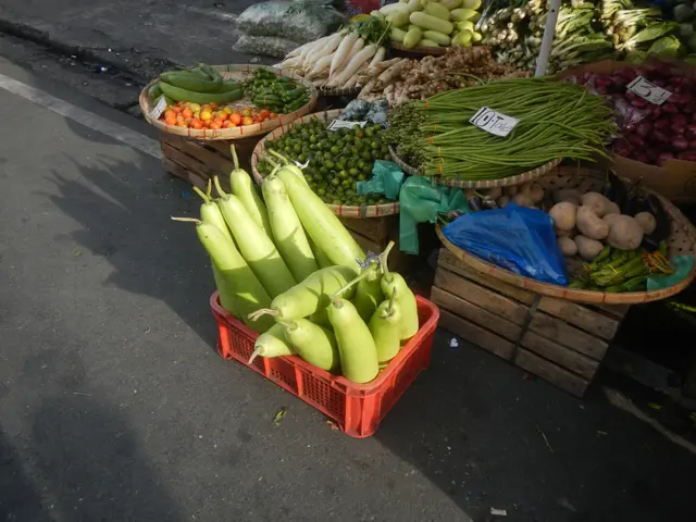 The image shows a street market with a variety of vegetables on display, including baskets filled...