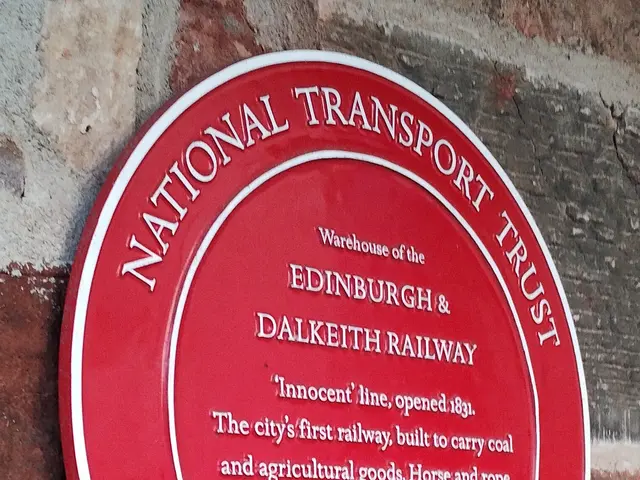 The image shows a red plaque on the side of a brick building that reads "National Transport Trust"....