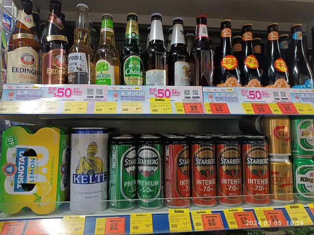 The image shows a shelf filled with lots of different types of beer, including bottles and tins,...
