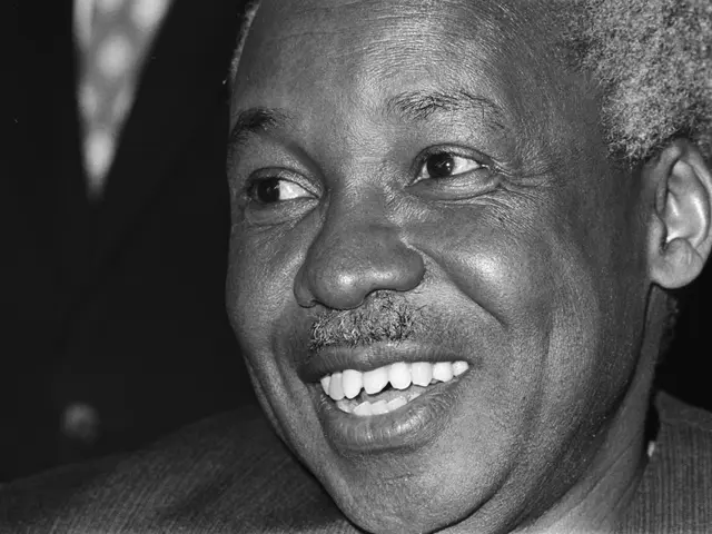 The image shows a black and white photo of Martin Luther King Jr. smiling, with a blurred...