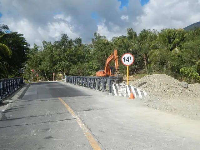 The image shows a bridge with railings on either side, a sign board with a pole, an excavator,...