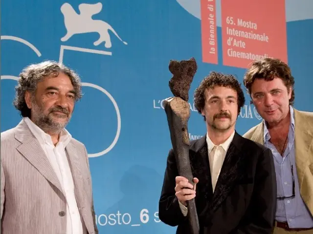 The image shows three men standing next to each other, with one of them holding an object in his...