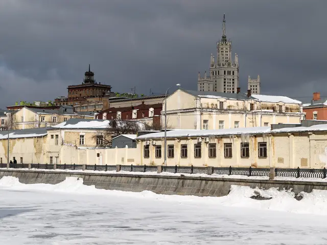 The image shows a view of a city with snow on the ground and buildings in the background. We can...