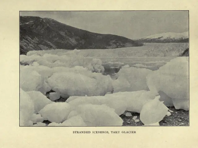 The image shows a black and white photo of a large iceberg in the middle of a body of water,...