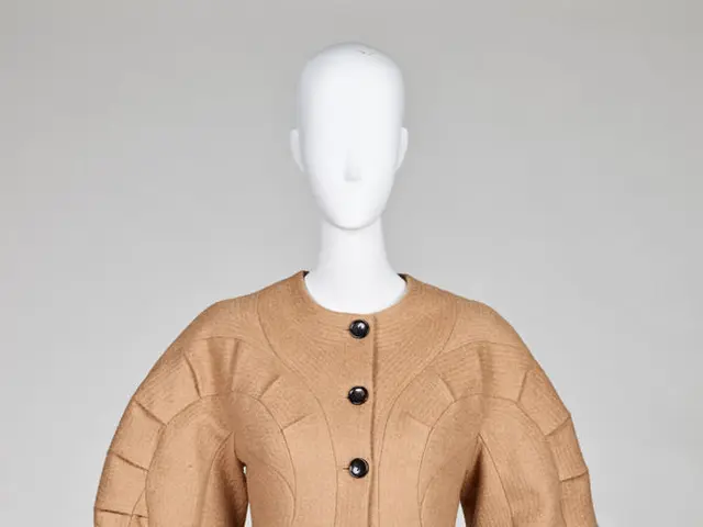 The image shows a mannequin wearing a Chanel beige wool and cashmere jacket with black pants...