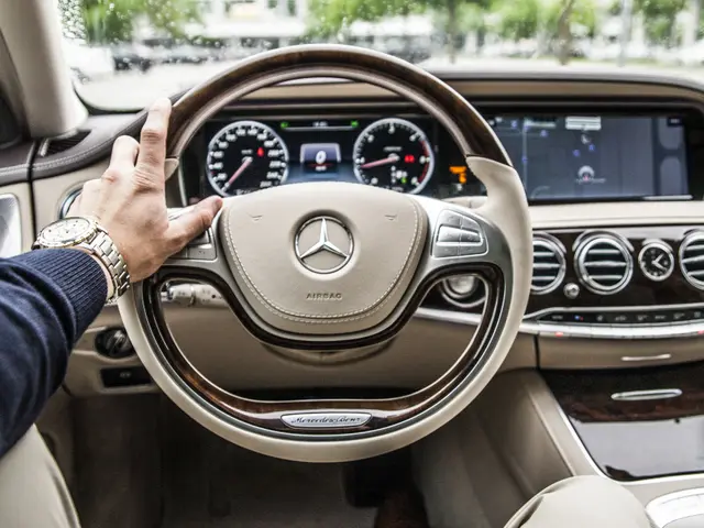 The image shows a man driving a 2017 Mercedes-Benz S-Class, with his hand on the steering wheel....