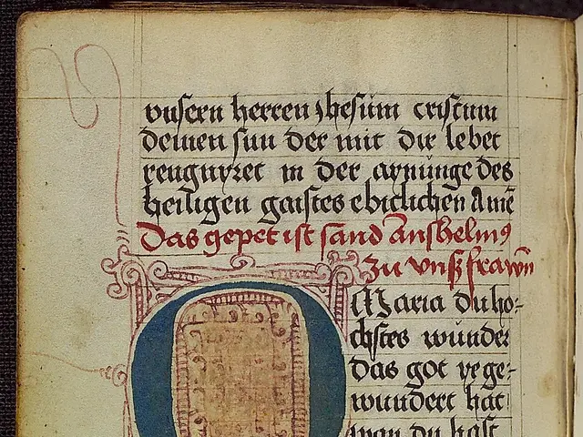 The image shows an open book with an illuminated manuscript featuring a letter 'O' in the center,...