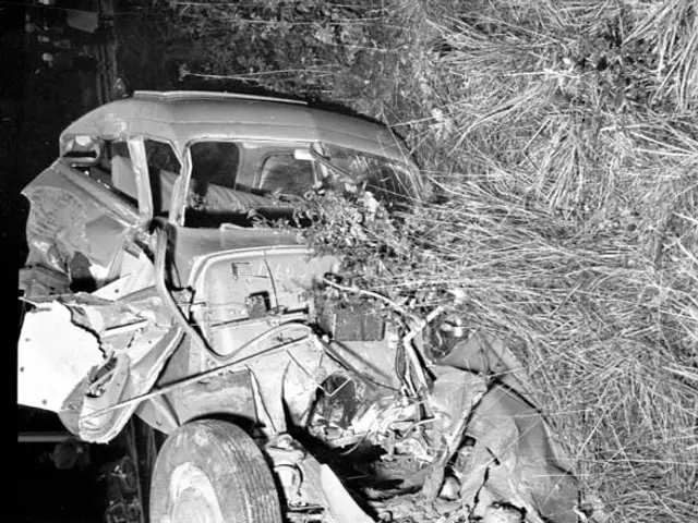 The image shows a black and white photo of a car that has been involved in a crash on the side of...
