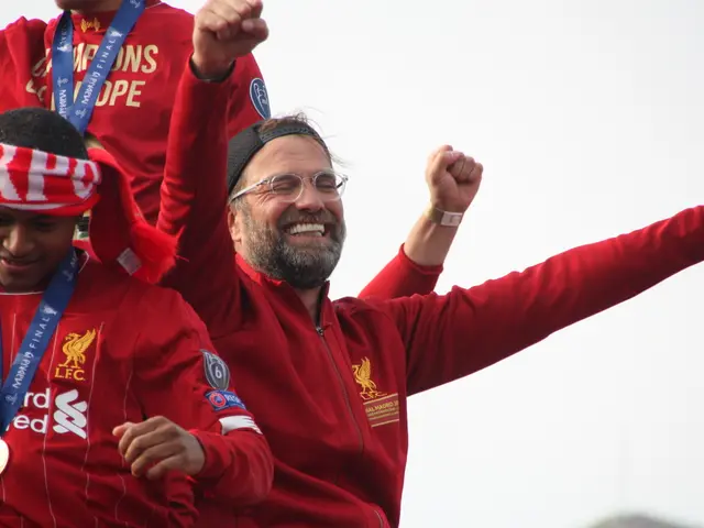 The image shows Liverpool manager Jurgen Klopp celebrating with his players after winning the UEFA...