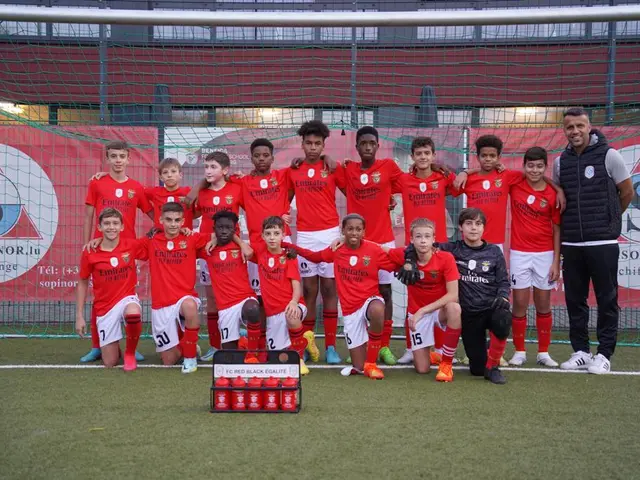 The image shows a group of young men standing next to each other on a soccer field. They are...