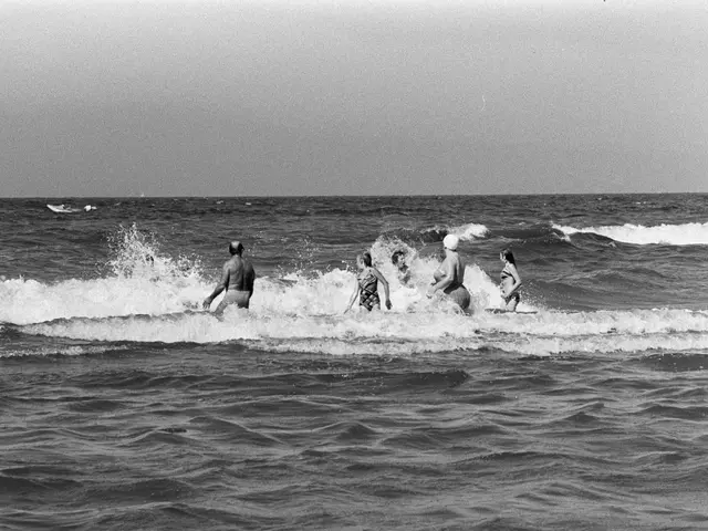 The image shows a group of people riding surfboards on top of a wave in the ocean, with the sky in...