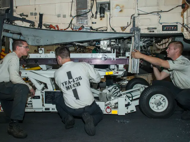 The image shows three men working on a plane in a hangar. They are wearing uniforms and are...