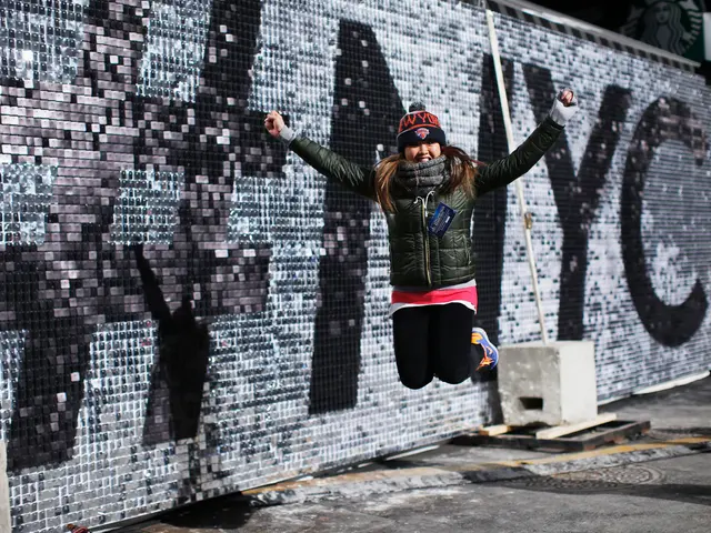 The image shows a woman jumping in the air in front of a wall with the words "New York City"...