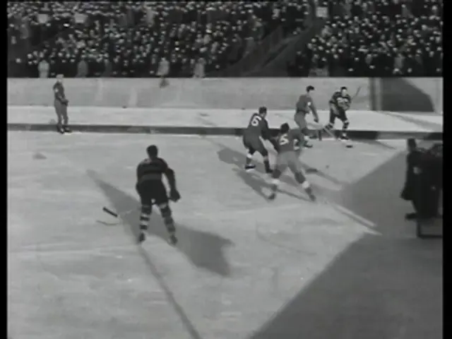 The image shows a group of men playing a game of hockey on an ice rink, with a crowd of spectators...