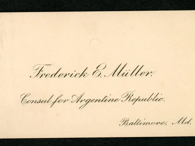 The image shows a black and white photo of a business card with the words "Frederick E. Miller...