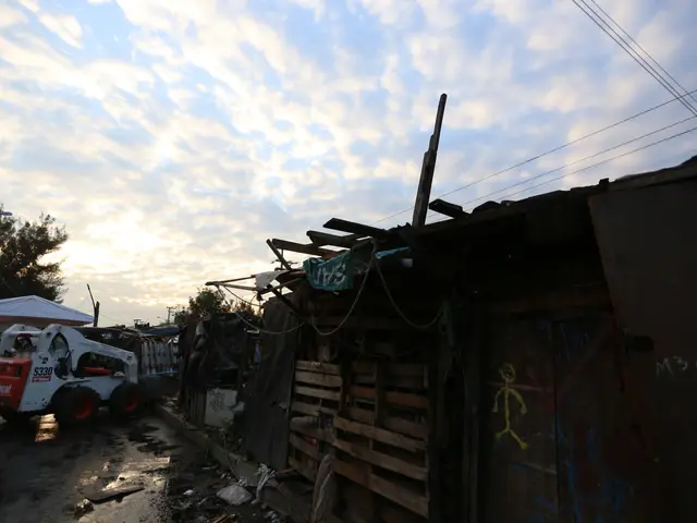 The image shows a truck parked in front of a building that has been torn down, surrounded by a...