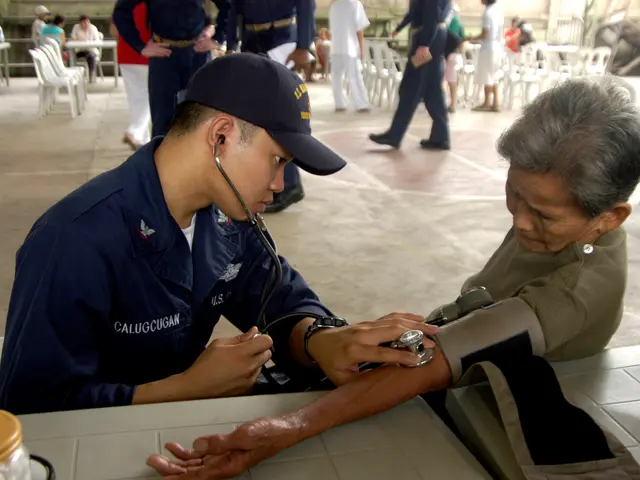 The image shows a man wearing a cap and holding a stethoscope, checking the blood pressure of an...