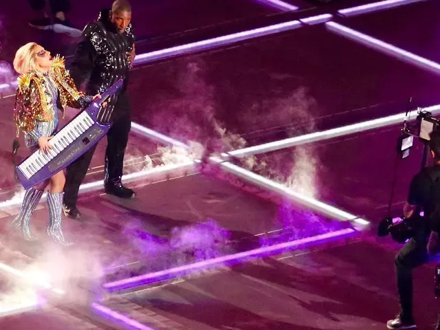 The image shows Lady Gaga and Kanye West performing at the Super Bowl halftime show. Lady Gaga is...